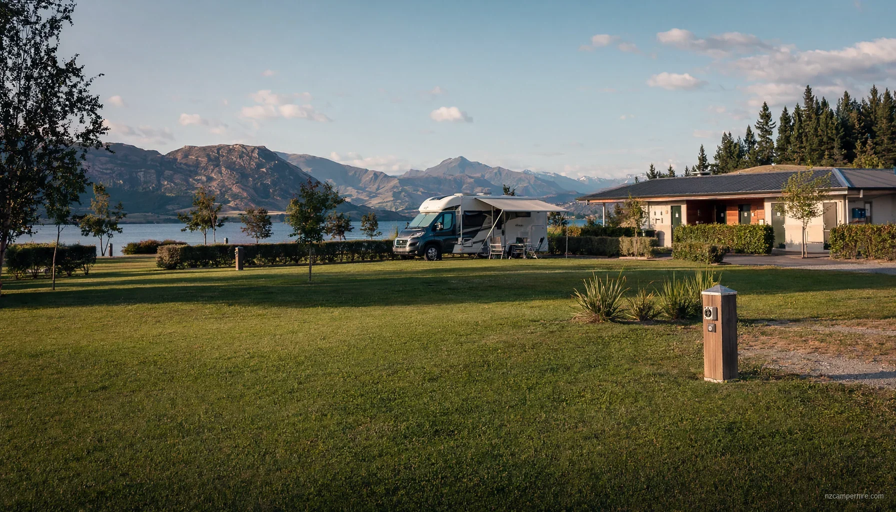 A serviced NZ holiday park with motorhomes and a tidy lawn