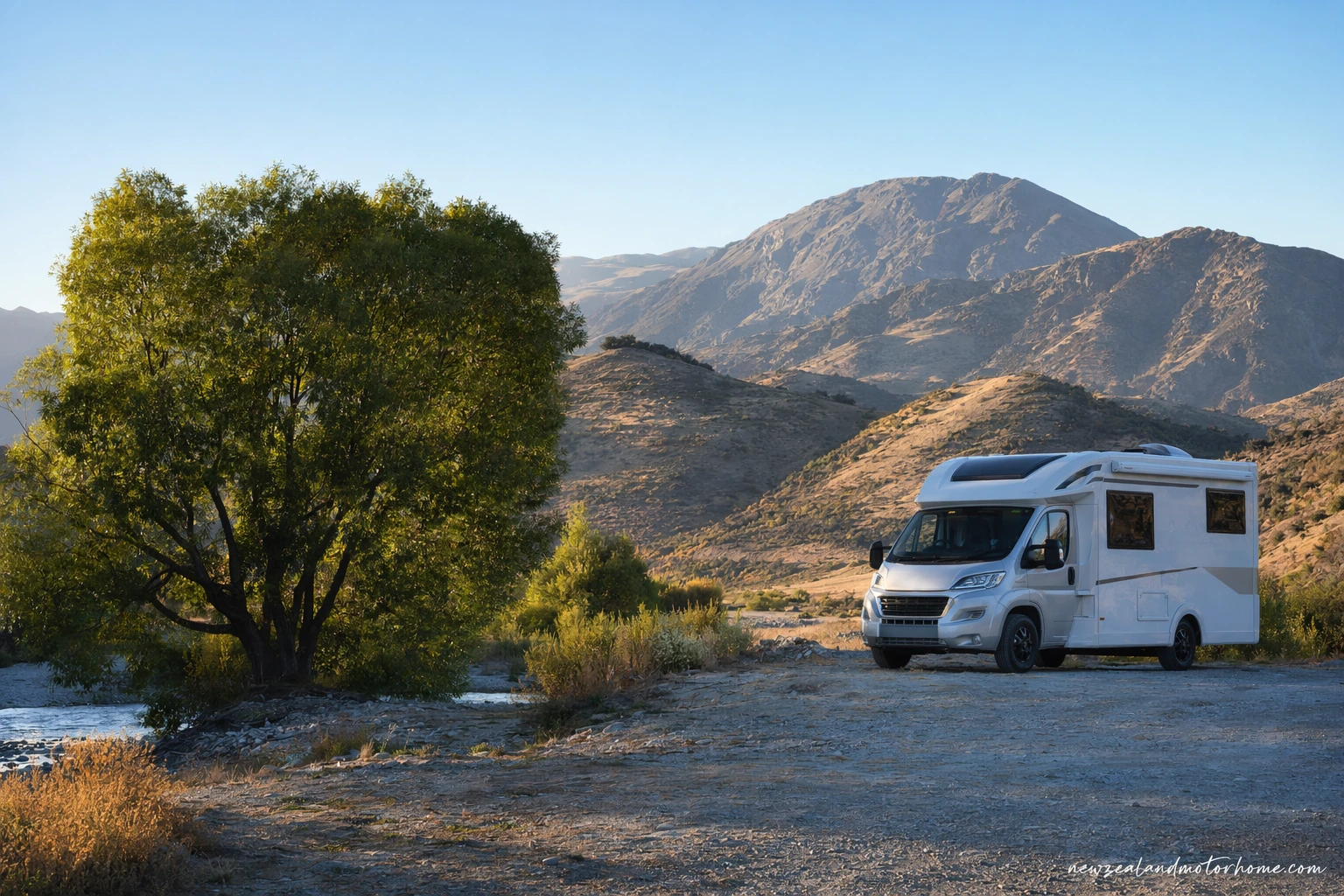 Campervan parked above vineyards and golden hills in Central Otago