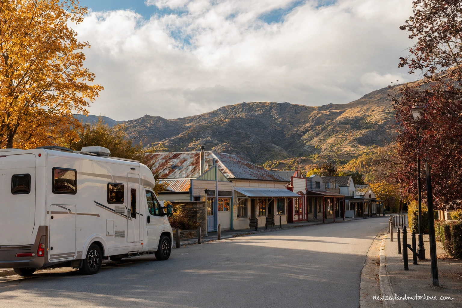 Campervan parked near Arrowtown with autumn trees and the historic village streets nearby
