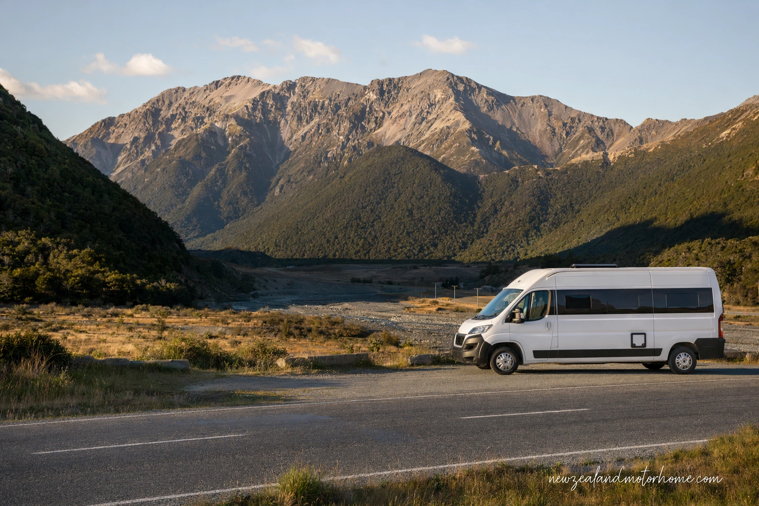 Campervan parked near Arthur's Pass with alpine peaks and beech forest around the road