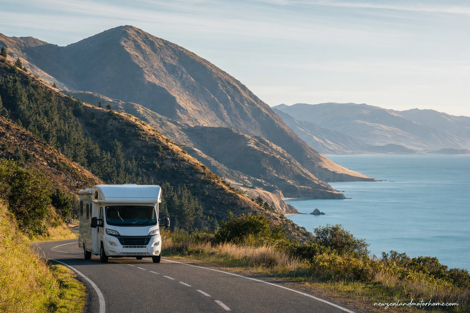 Campervan parked above a sheltered bay in the Marlborough Sounds