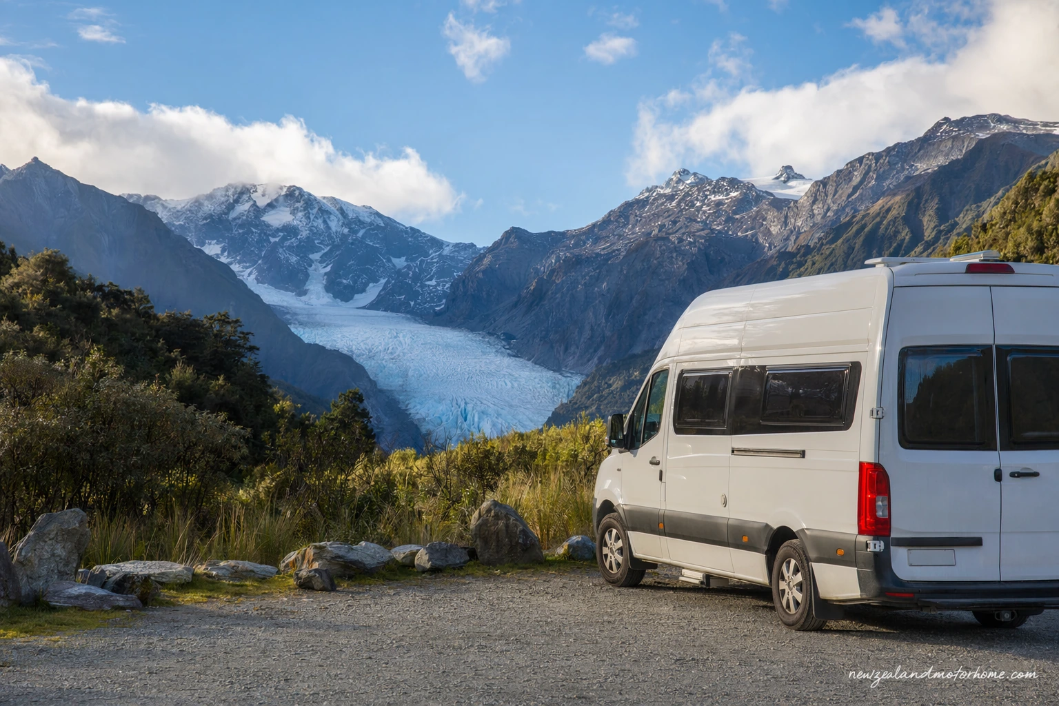 Campervan parked near rainforest and mountain views in New Zealand West Coast glacier country