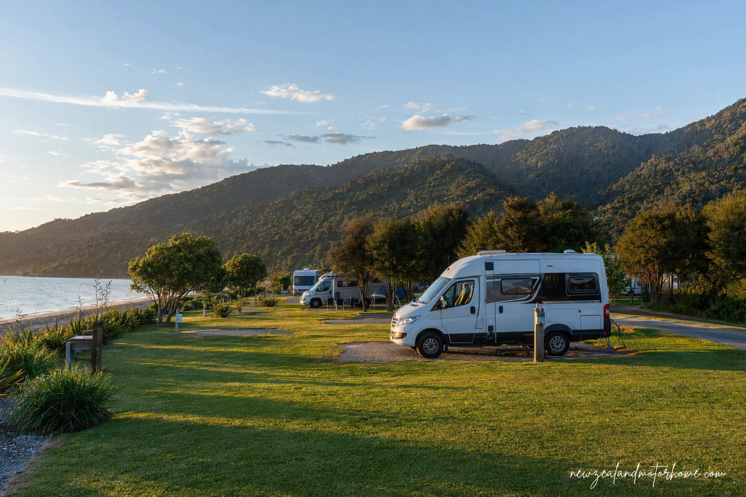 Campervan parked near the beach at Abel Tasman with native bush and golden sand nearby