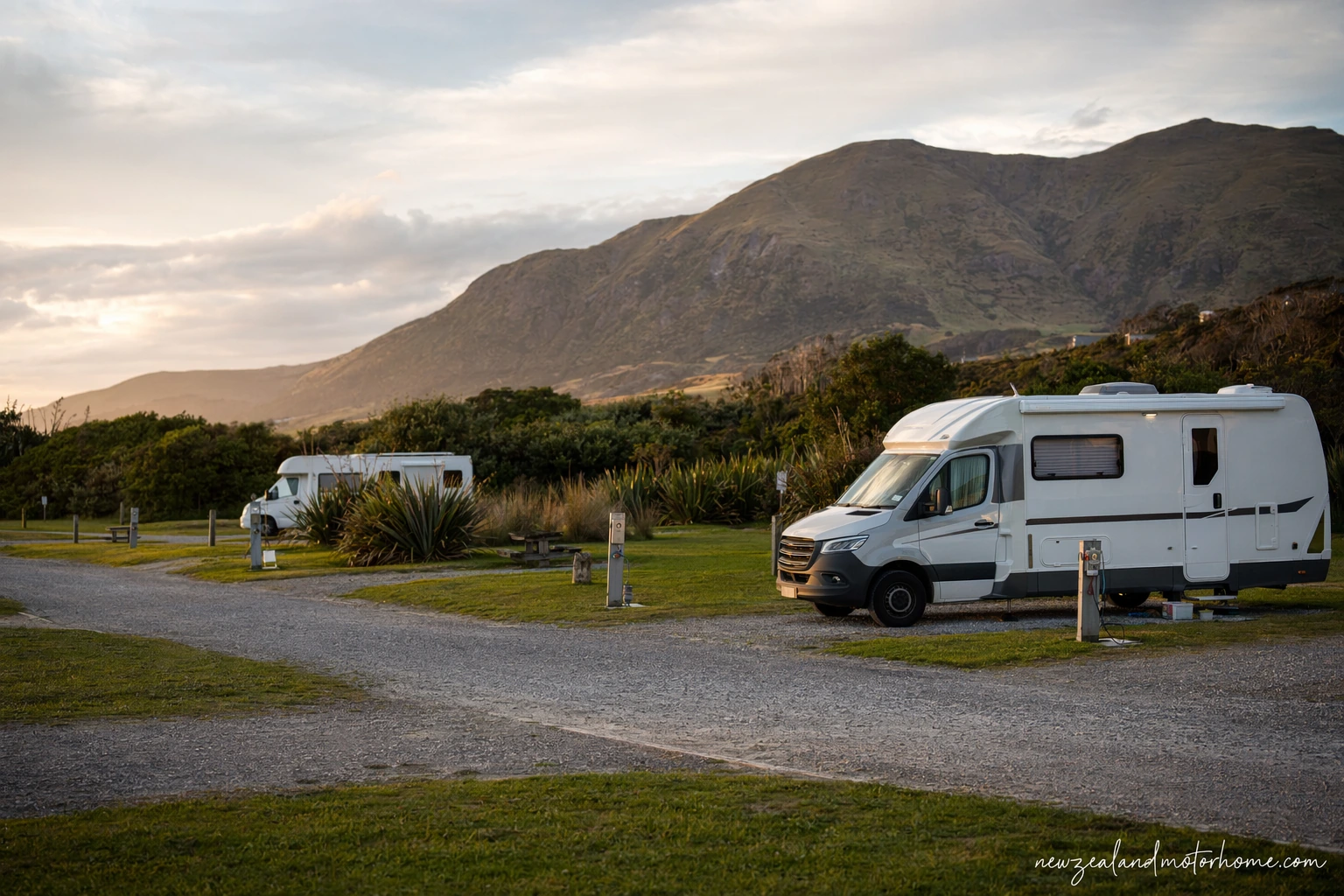 Campervan parked near the Catlins coast with native bush, beach and rolling hills in the background