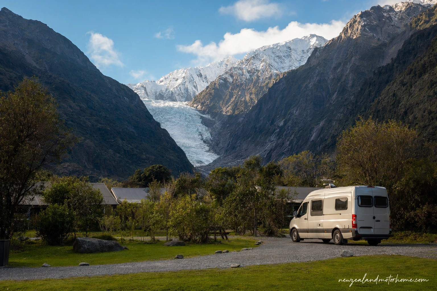 Campervan parked near Fox Glacier village with rainforest and Southern Alps cloud behind