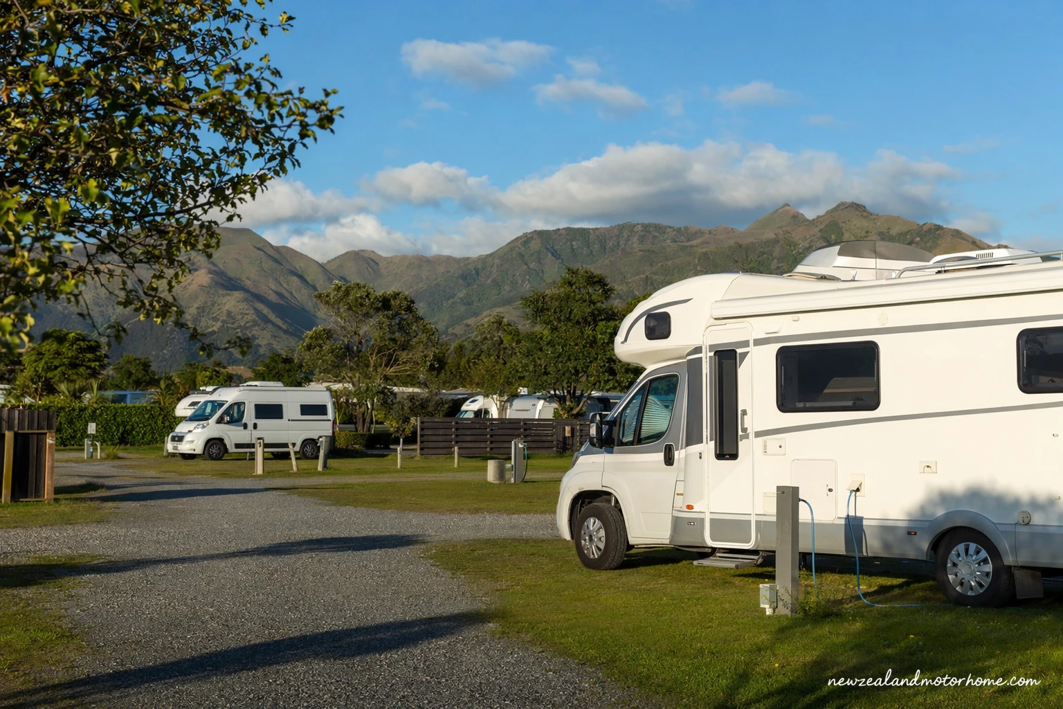 Campervan parked at a coastal holiday park in Hawke's Bay with the beach and hills nearby