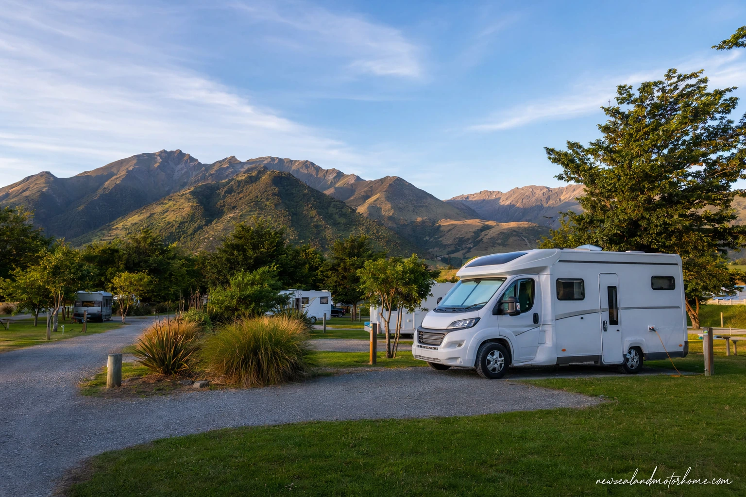 Campervan parked at a Marlborough holiday park near the Sounds with hills and water in the background