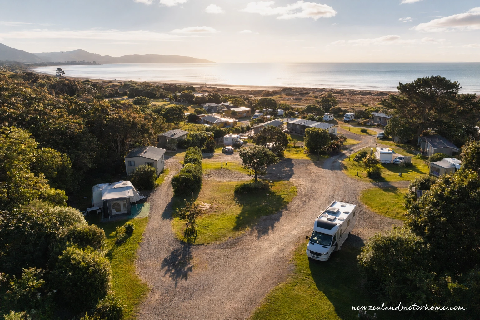Campervan parked on a powered site at a New Zealand holiday park near the coast